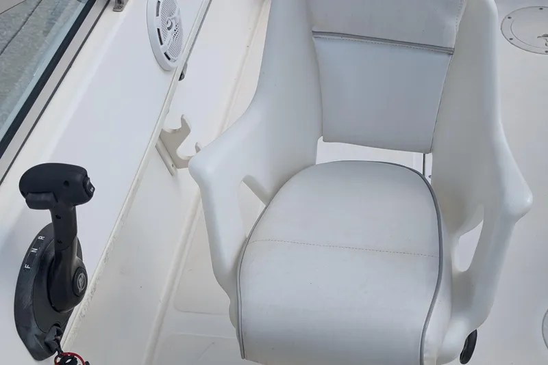 Slide: The Image of 1998 Boston Whaler Ventura 20 boat interior with white captain's chair and control lever. - 9