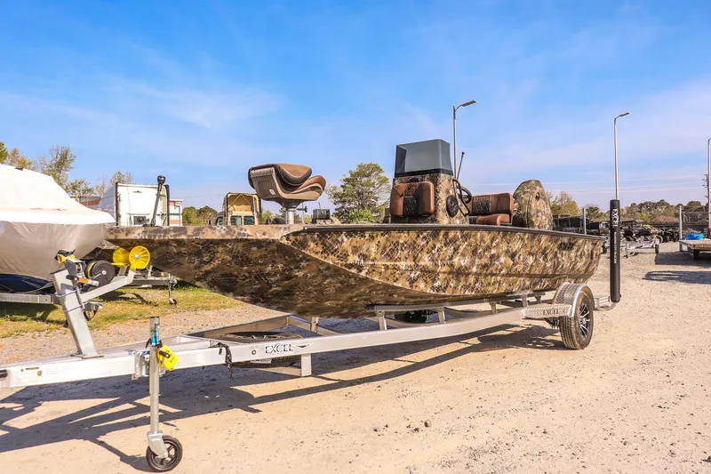 The Image of 2026 Excel 203 Bay Pro Elite boat on trailer, camo design, parked outdoors. - 1