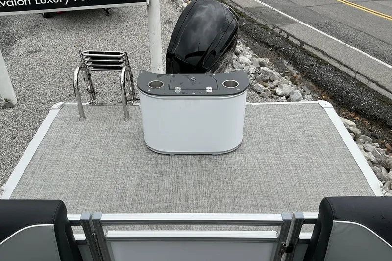 Slide: The Image of 2026 Avalon Venture 23 Quad Lounge boat deck with motor and seating area. - 10
