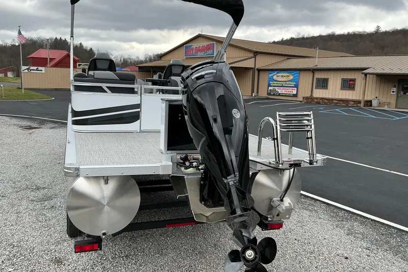 Slide: The Image of 2026 Avalon Venture 23 Quad Lounge pontoon boat with motor, parked outside dealership. - 3