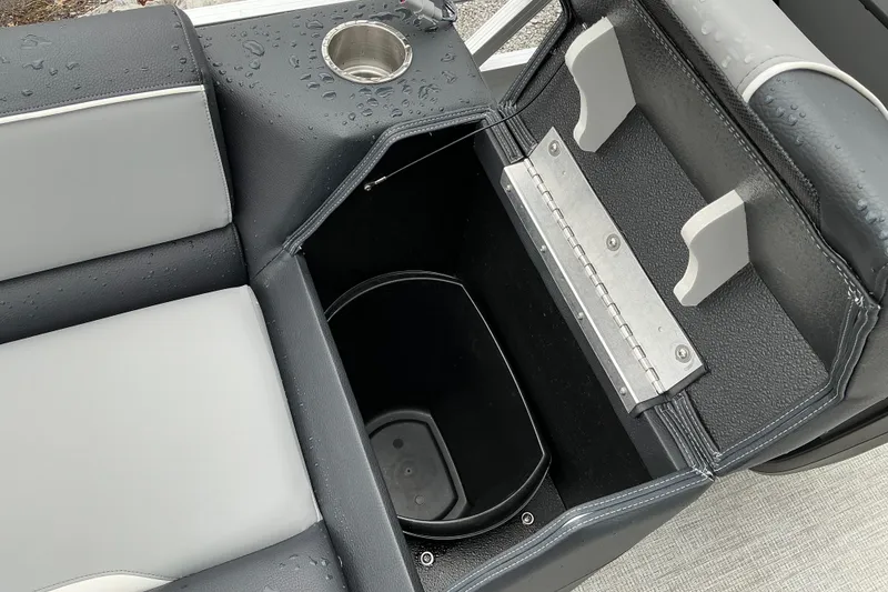 Slide: The Image of 2026 Avalon Venture 23 Quad Lounge seat storage with cup holder and wet surface. - 9