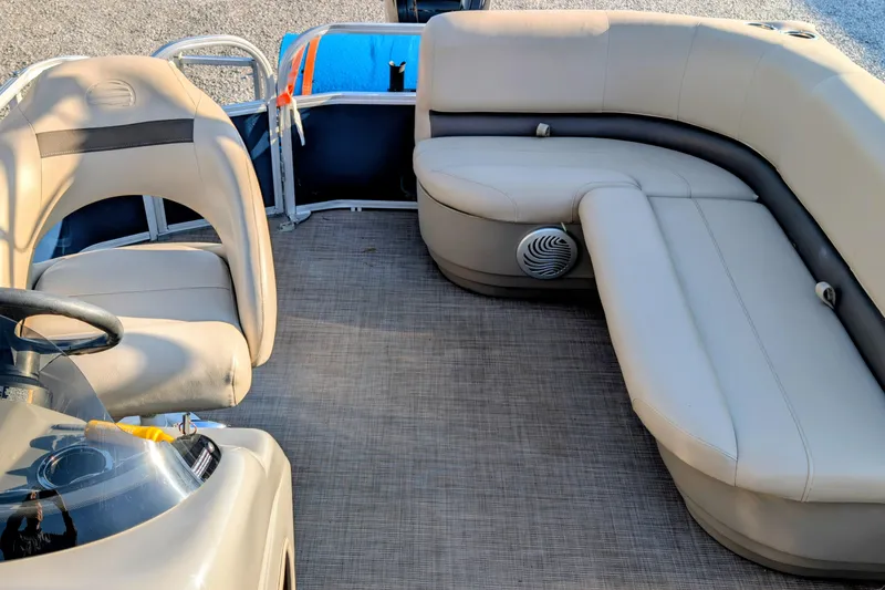 Slide: The Image of 2020 Sun Tracker Party Barge 18 interior with beige seating and steering console. - 7