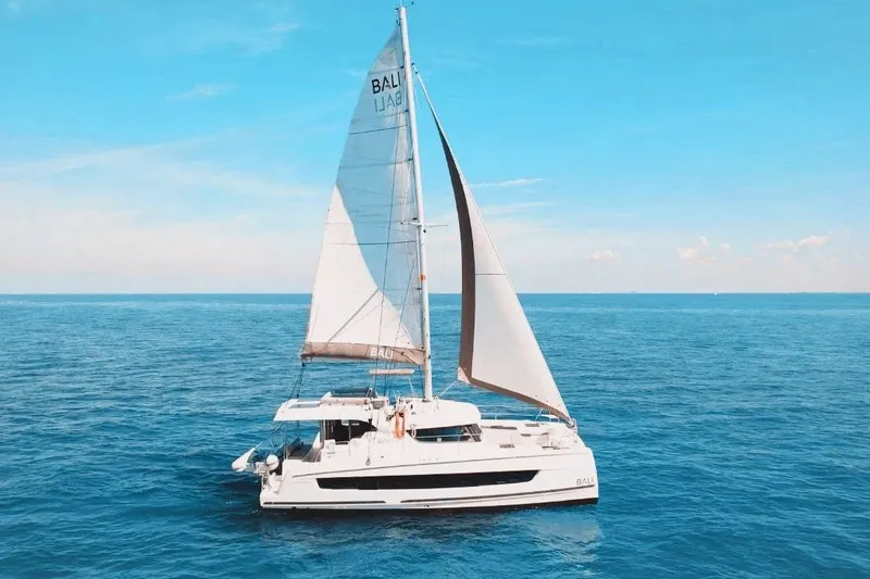The Image of 2023 Bali CATSPACE catamaran sailing on open blue sea under clear sky. - 0