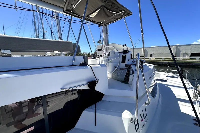 Slide: The Image of 2023 Bali CATSPACE catamaran helm station with modern design and marina backdrop. - 11