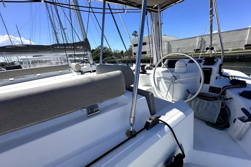 Slide: The Image of 2023 Bali CATSPACE yacht cockpit with steering wheel and marina view. - 12