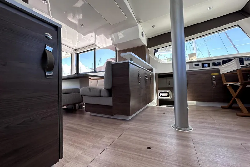 Slide: The Image of Interior of 2023 Bali CATSPACE catamaran featuring modern wood cabinetry and spacious seating area. - 14