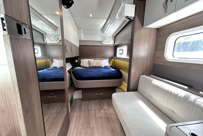 Slide: The Image of Luxurious 2023 Bali CATSPACE yacht interior with cozy bed, sofa, and modern wood finishes. - 24