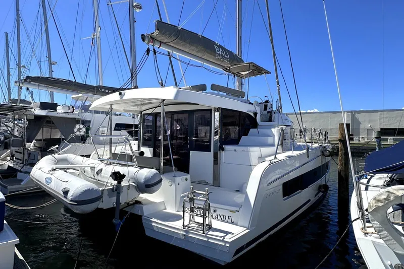 Slide: The Image of 2023 Bali CATSPACE catamaran docked at marina, featuring sleek design and inflatable dinghy. - 7