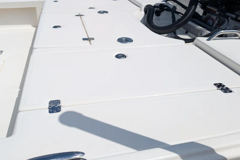 Slide: The Image of 2021 Mako 21 LTS boat deck with storage compartments and engine components. - 10