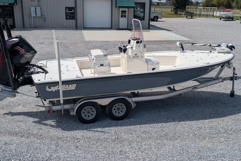 Slide: The Image of 2021 Mako 21 LTS boat on trailer, parked outside a building. - 2