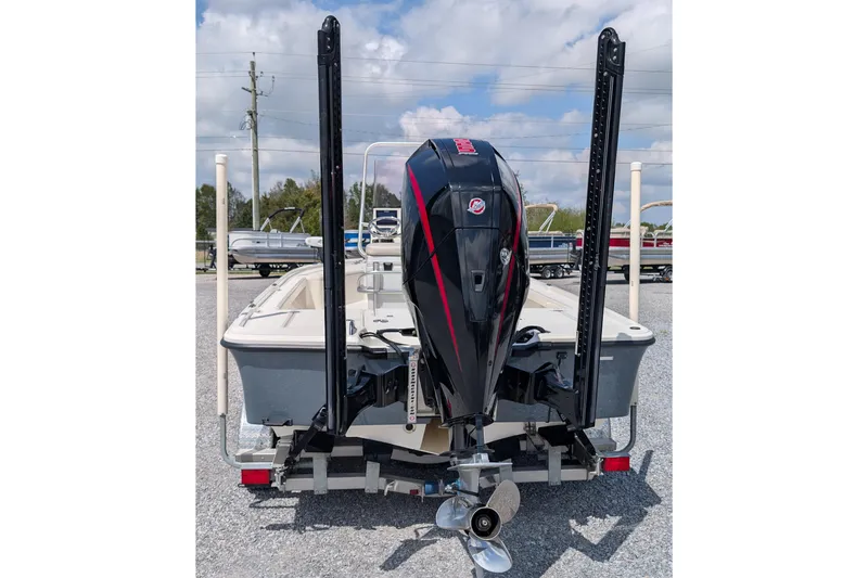 Slide: The Image of 2021 Mako 21 LTS boat with powerful outboard motor, parked on gravel lot. - 3