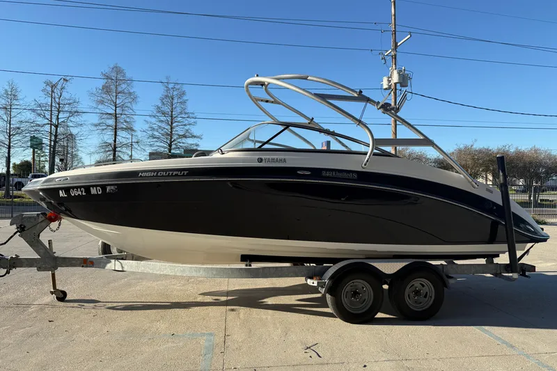 Slide: The Image of 2011 Yamaha Boats 242 Limited S on trailer, black and white design, parked outdoors. - 6