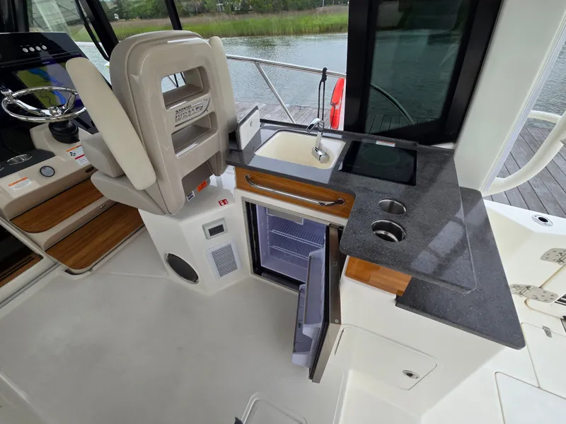 Slide: The Image of Interior of 2026 Boston Whaler 365 Conquest with kitchenette and fridge. - 22