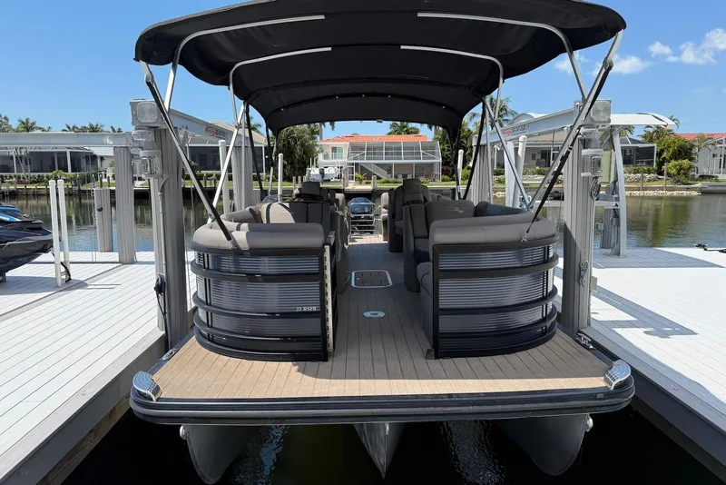 The Image of 2019 Bennington R 23 RSFB pontoon boat docked at a marina under a sunny sky. - 0