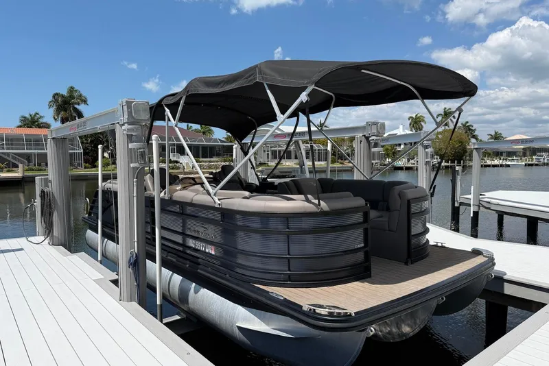 Slide: The Image of 2019 Bennington R 23 RSFB pontoon boat docked under a sunny sky. - 2
