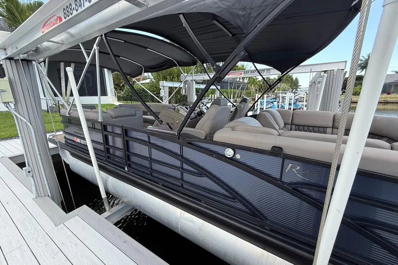 Slide: The Image of 2019 Bennington R 23 RSFB pontoon boat docked with canopy and plush seating. - 3