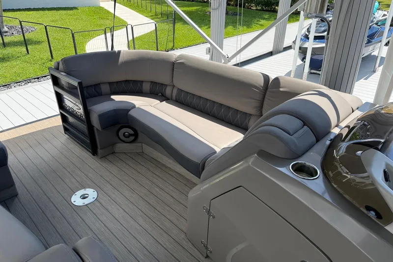Slide: The Image of Luxurious seating on 2019 Bennington R 23 RSFB pontoon boat, docked with lush greenery. - 7