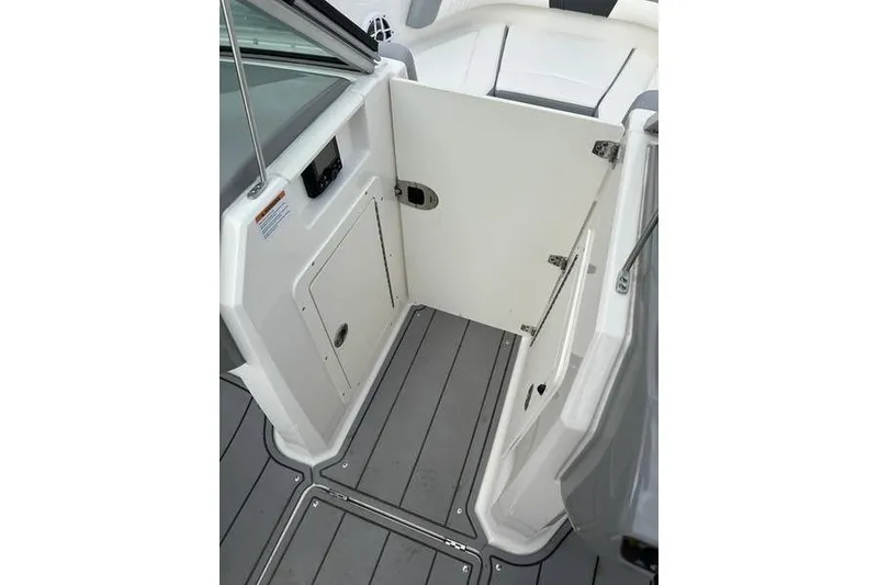 Slide: The Image of 2023 Chaparral 21 SSi boat interior with open storage compartment and sleek flooring. - 15