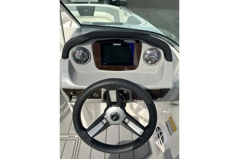 Slide: The Image of 2023 Chaparral 21 SSi boat dashboard with steering wheel and Simrad display. - 16