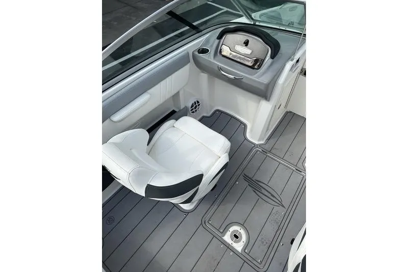 Slide: The Image of 2023 Chaparral 21 SSi boat interior with white seating and sleek dashboard design. - 17
