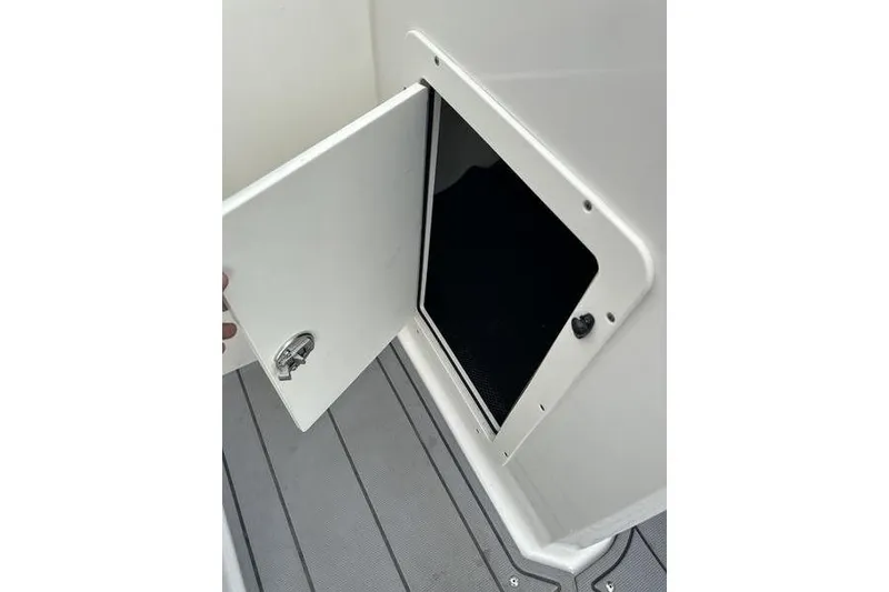Slide: The Image of 2023 Chaparral 21 SSi boat storage compartment with open door on deck. - 20