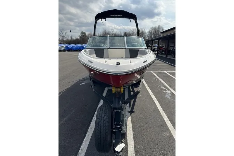 Slide: The Image of 2023 Chaparral 21 SSi boat on trailer, parked outdoors under cloudy sky. - 4