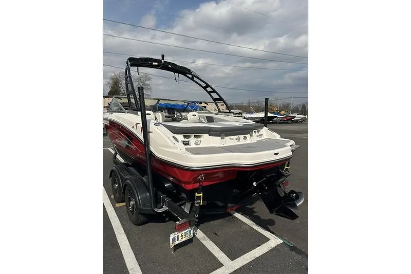 Slide: The Image of 2023 Chaparral 21 SSi boat with red and white exterior, parked on a trailer. - 5