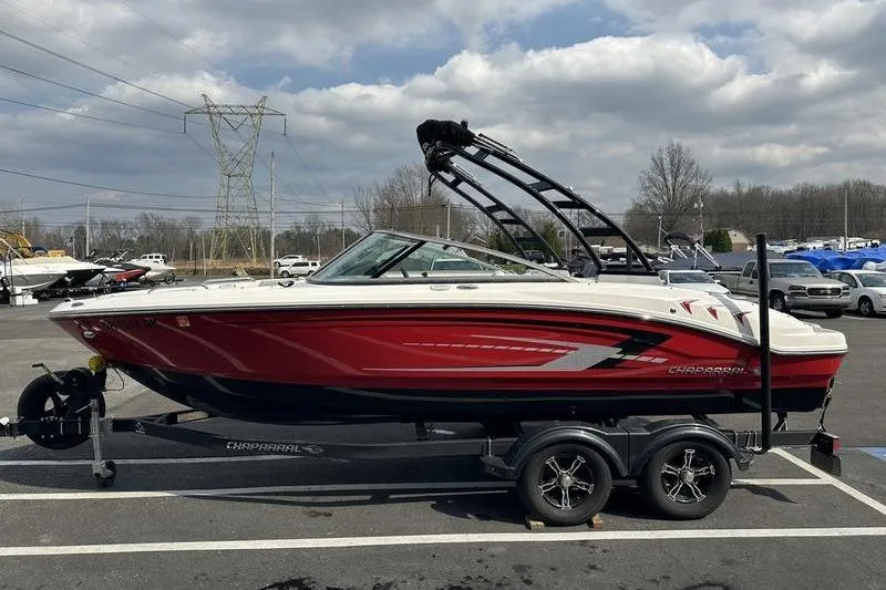 Slide: The Image of 2023 Chaparral 21 SSi boat on trailer, red and white design, parked outdoors. - 6
