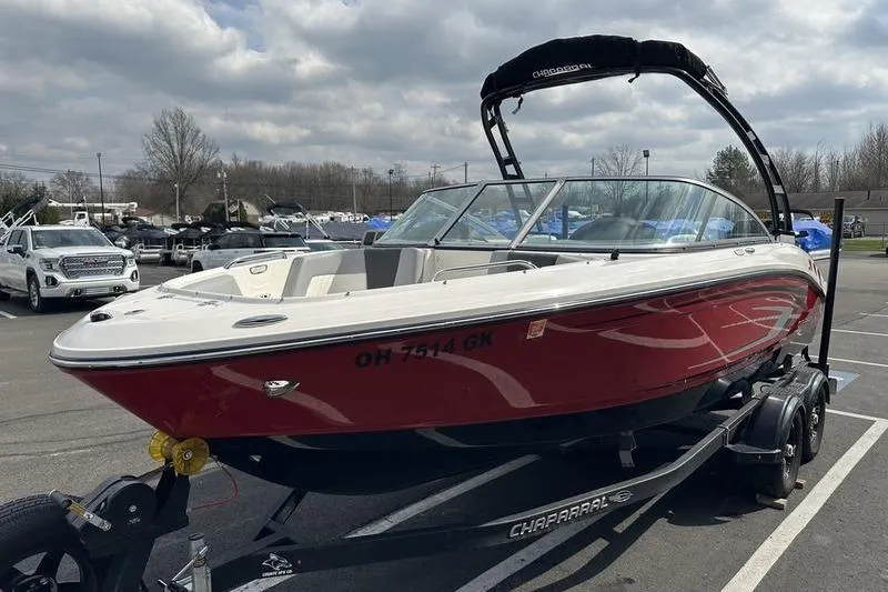 Slide: The Image of 2023 Chaparral 21 SSi boat in parking lot, red and white exterior, on trailer. - 7