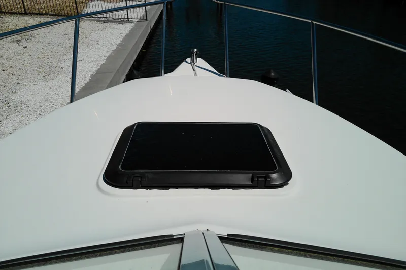 Slide: The Image of Bow of a 2009 Key West 2020 Walkaround boat with a hatch, docked by water. - 17