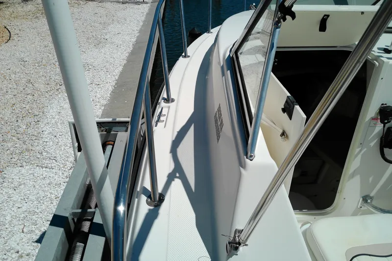 Slide: The Image of 2009 Key West 2020 Walkaround boat docked, showing side railings and cabin entrance. - 24