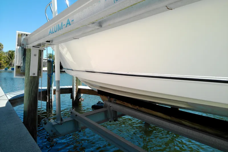 Slide: The Image of Boat lift holding Key West 2020 Walkaround, 2009 model, above water in marina. - 26