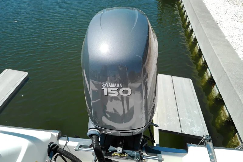 Slide: The Image of Outboard motor on 2009 Key West 2020 Walkaround boat, docked by water. - 4