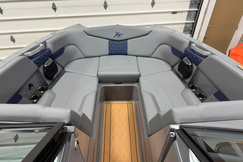 Slide: The Image of 2026 MasterCraft XT22 boat interior with gray seating, cup holders, and premium finishes. - 14