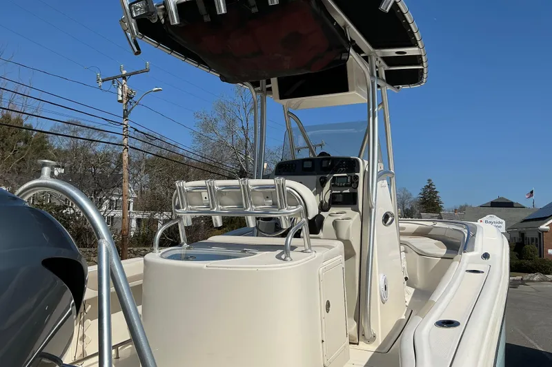 Slide: The Image of 2014 Pioneer 222 Sportfish boat with center console and T-top under clear blue sky. - 3