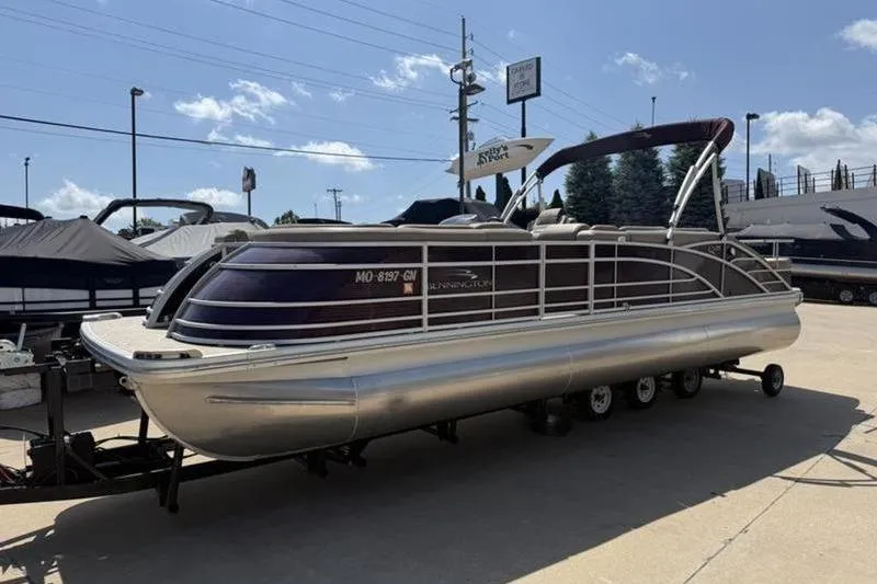 The Image of 2020 Bennington 25 QSBIO pontoon boat on trailer in sunny marina. - 1