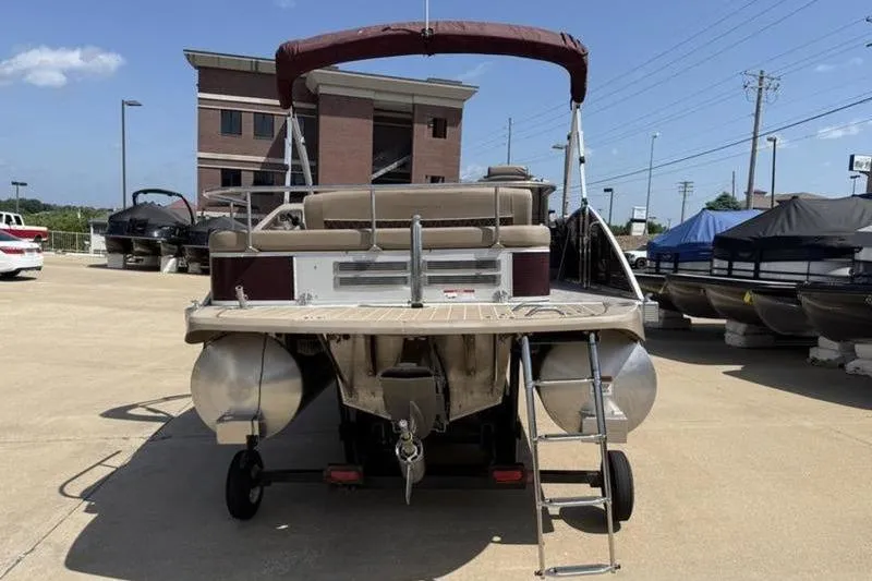 Slide: The Image of 2020 Bennington 25 QSBIO pontoon boat with ladder, parked outdoors. - 6