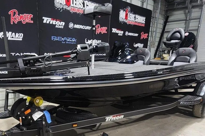 Slide: The Image of 2026 Triton 20XP Patriot boat displayed indoors with branded backdrop. - 4