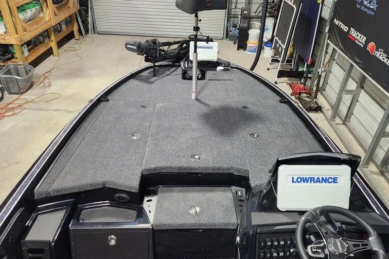 Slide: The Image of 2026 Triton 20XP Patriot boat interior with Lowrance electronics in a garage setting. - 8