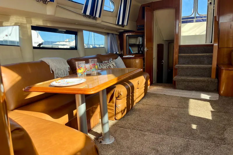 Slide: The Image of Luxurious interior of 2004 Carver 444 Cockpit Motor Yacht with leather seating and dining area. - 11
