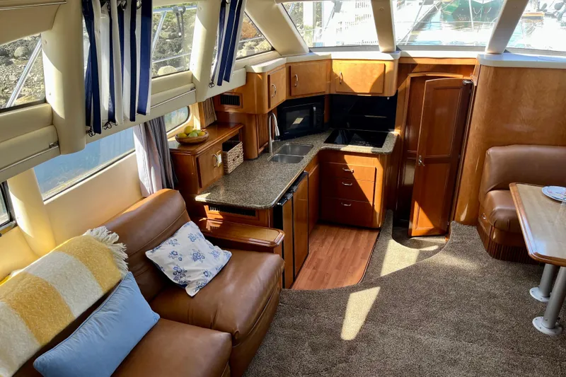 Slide: The Image of Interior of 2004 Carver 444 Cockpit Motor Yacht with cozy seating and modern kitchen. - 12