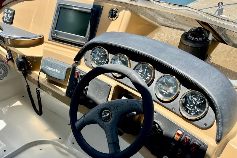 Slide: The Image of 2004 Carver 444 Cockpit Motor Yacht helm with gauges, steering wheel, and navigation equipment. - 19