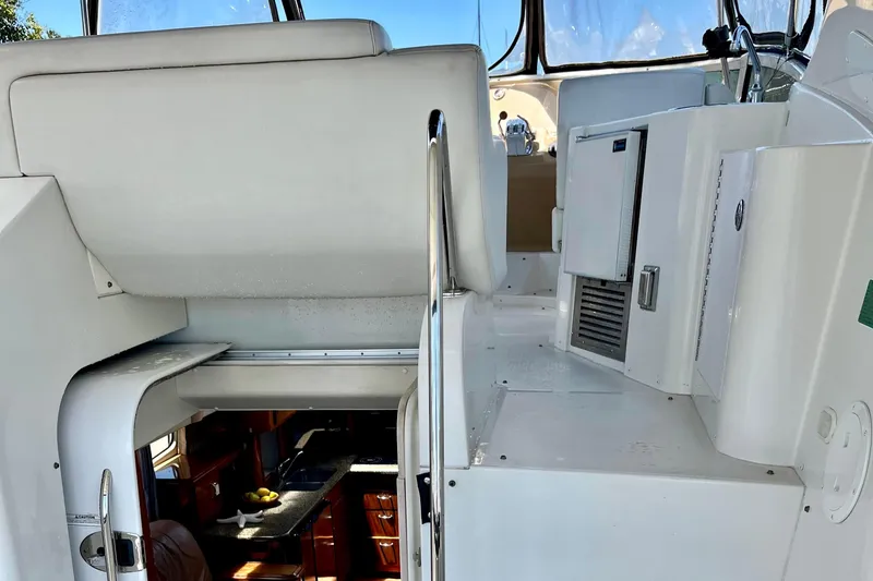 Slide: The Image of 2004 Carver 444 Cockpit Motor Yacht interior with white seating and kitchenette. - 20