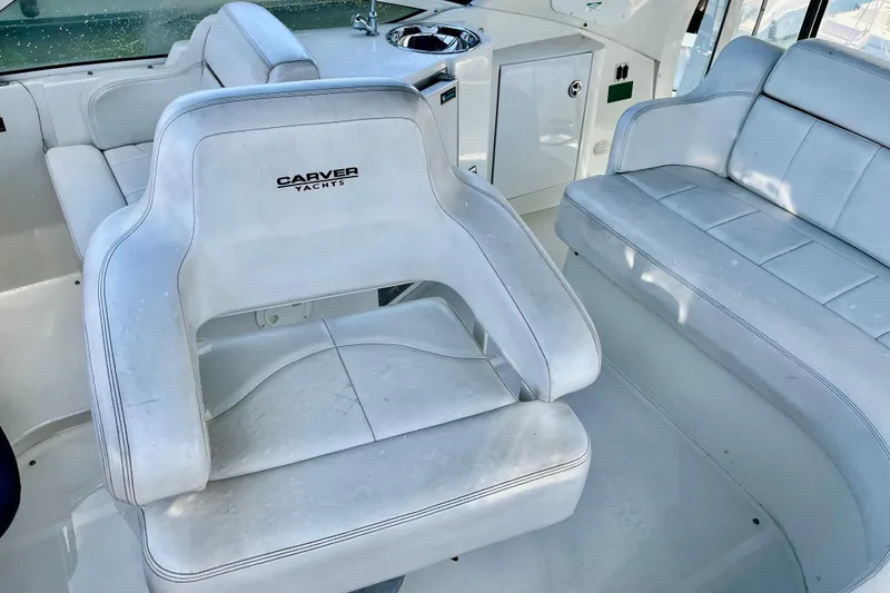 Slide: The Image of 2004 Carver 444 Cockpit Motor Yacht interior with white seating and helm chair. - 21