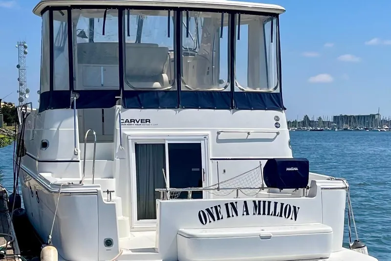 Slide: The Image of 2004 Carver 444 Cockpit Motor Yacht docked, named "One in a Million," with blue canopy. - 3