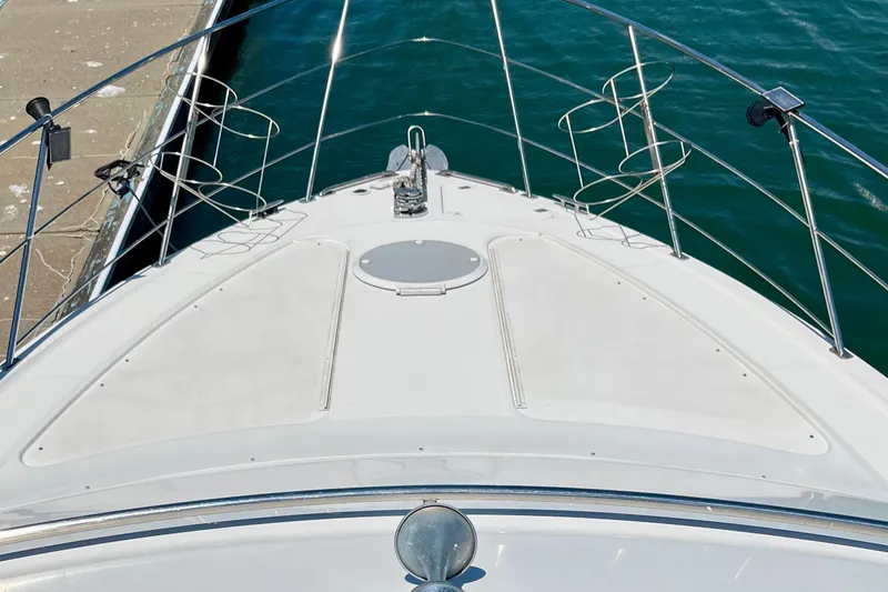 Slide: The Image of Bow view of 2004 Carver 444 Cockpit Motor Yacht docked by the water. - 4