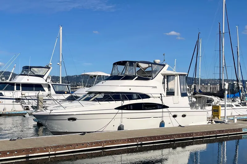 Slide: The Image of 2004 Carver 444 Cockpit Motor Yacht docked at marina under clear blue sky. - 5