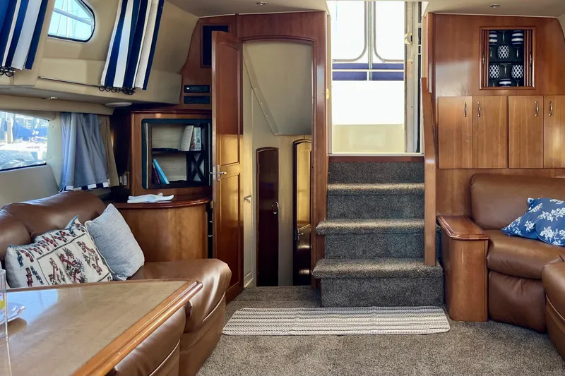 Slide: The Image of Luxurious interior of 2004 Carver 444 Cockpit Motor Yacht with plush seating and wooden accents. - 6