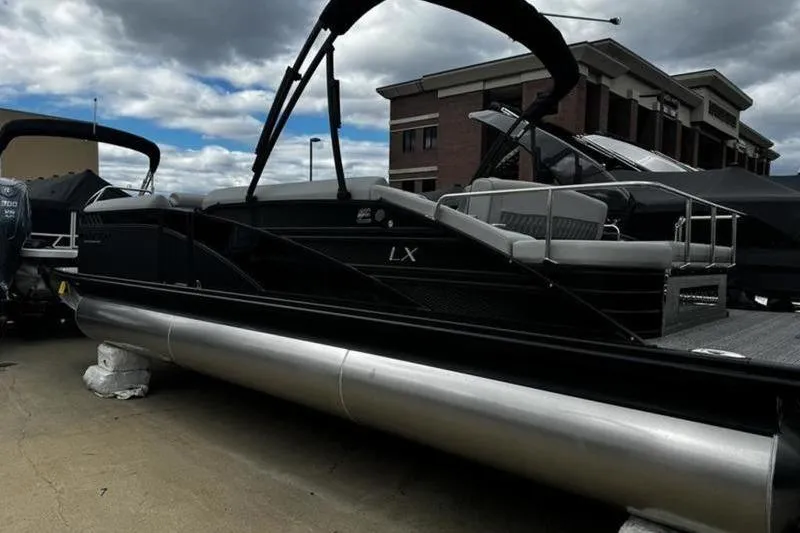 Slide: The Image of 2025 Bennington 26 LXSSB pontoon boat displayed outdoors under cloudy sky. - 3