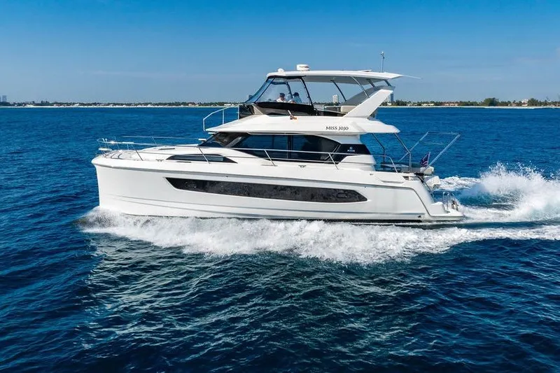 Slide: The Image of 2024 Aquila 44 Yacht cruising on open blue water under clear skies. - 13